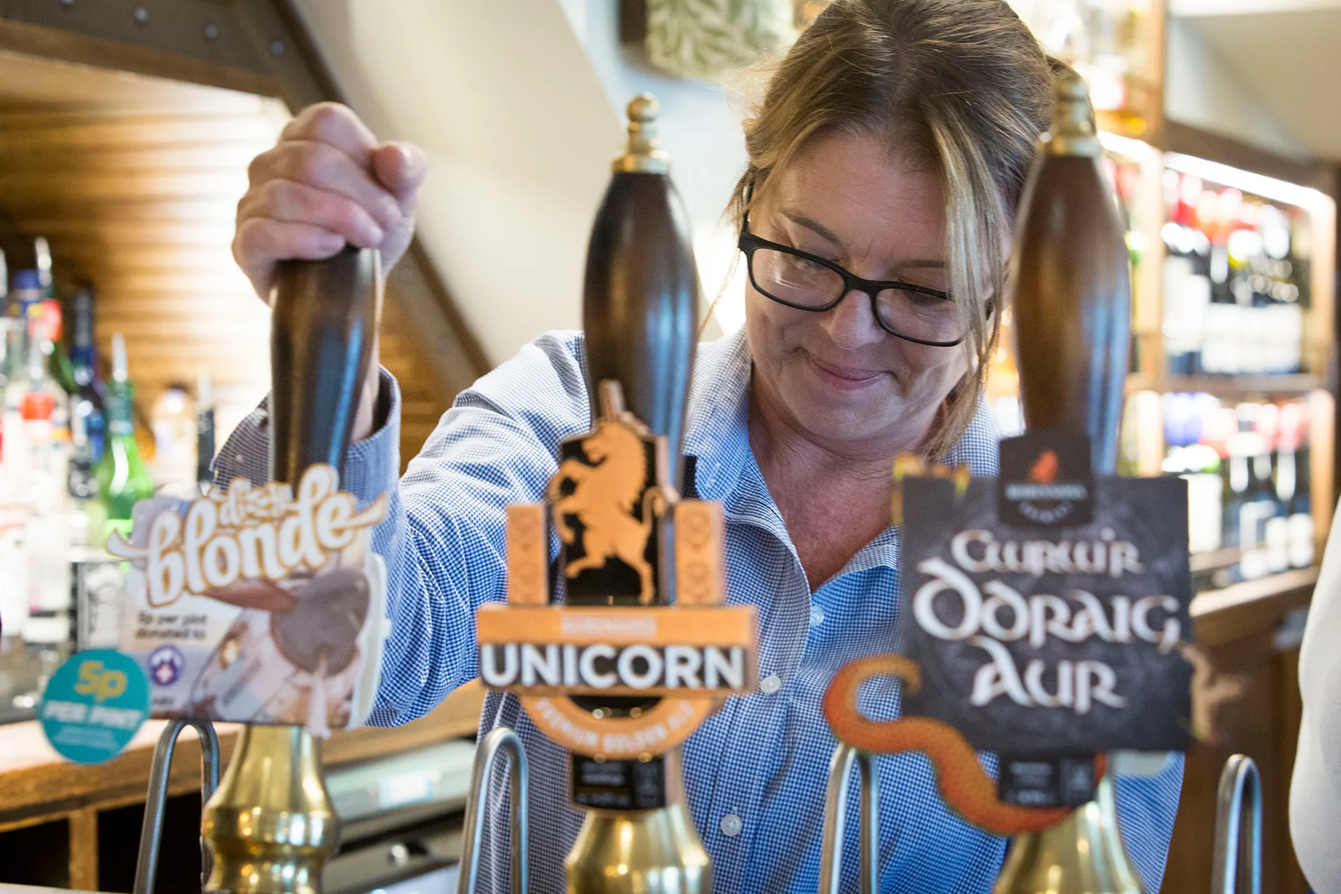 A lady pouring a pint