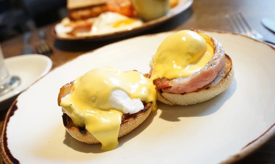 A bacon and cheese bap. The cheese is melted.
