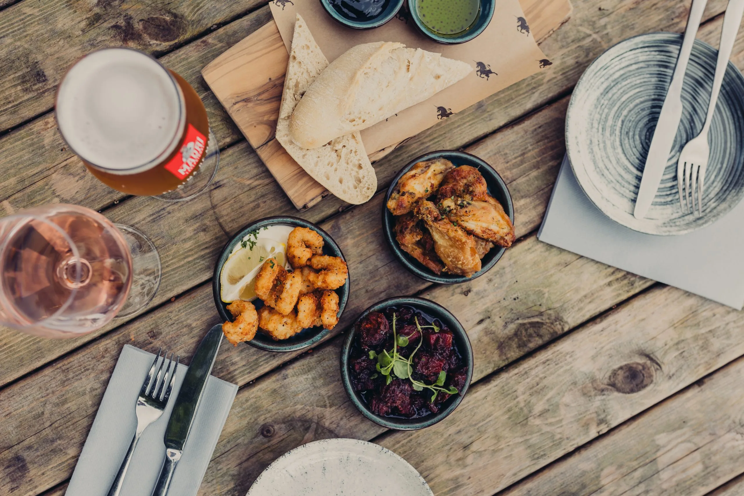 Various small dishes on a table with someone putting their fork into one