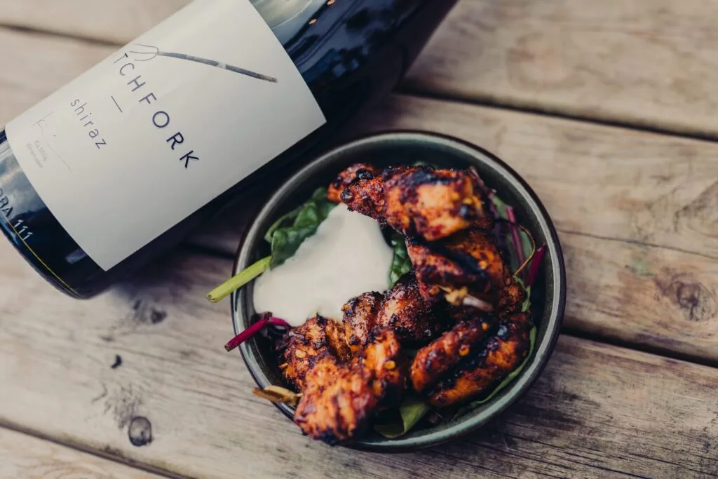 A dish next to a wine bottle that's slightly out of frame