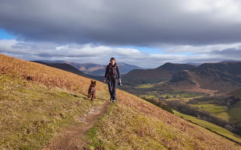 Someone standing on a hill - behind him are some more hills